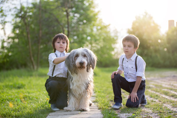 Little preschool boy, cute child, dressed in vintage style clothes, with their pet dog friend