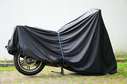 motorcycle, motorbike under the tarpaulin. parking for motorcycles. moto camping