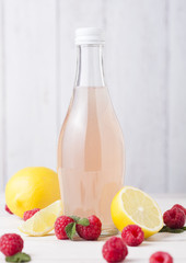 Bottle of cold raspberry soda drink with lemon