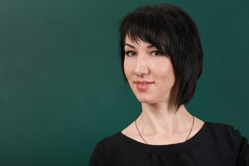 teacher posing by chalk Board, learning concept, green background, Studio shot