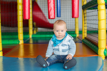 Fototapeta na wymiar Little baby boy, playing in indoor playground