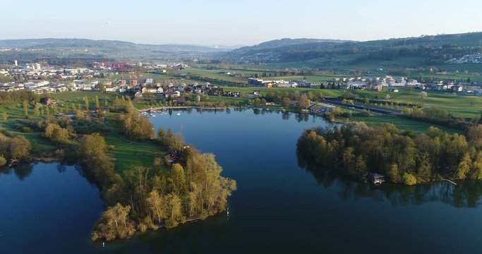 Aerial view on a spring morning from the lake shore of Lake Sempach with the city of Sursee in background in central Switzerland