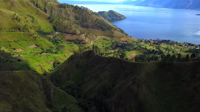 AERIAL 4K: Flying over trees to view of Toba lake, the most popular touris destination in Indonesia