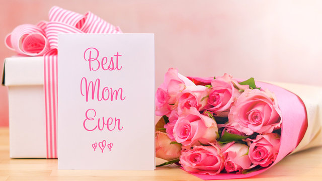 Happy Mother's Day gift, pink roses and Best Mom Ever greeting card on table.