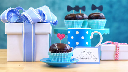 Happy Father's Day close of gifts, cupcakes and coffee on table.