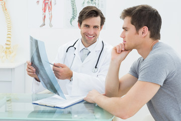 Smiling doctor explaining spine xray to patient