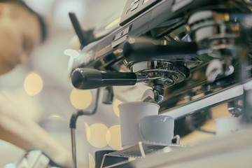 Unrecognizable barista, working at bar. Making coffee in coffee machine. Fresh espresso. Coffee culture and professional coffee making, service, catering concepts
