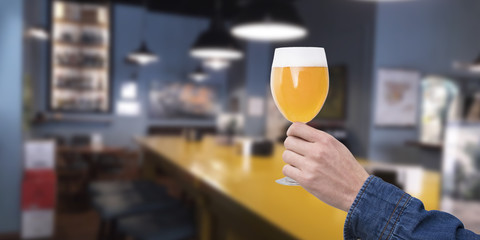 hand with a glass of beer in the bar or pub