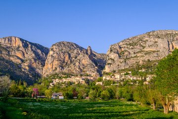 Naklejka na ściany i meble Vue panoramique sur le village de Moustiers Sainte-Marie. Alpes de Haute Provence, France. Coucher de solei.