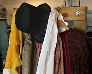 Old vintage clothes including top hat, smoking jacket, silk jacket, scarves in yellow, white and crimson - obrazy, fototapety, plakaty