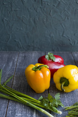 red and yellow peppers, green onion on the dark blue background