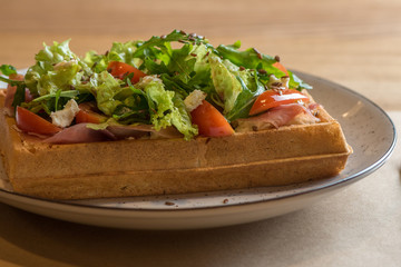 Homemade Belgian Waffle with salad Iceberg, tomatoes and ham