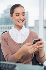 Obraz premium Smiling beautiful businesswoman text messaging
