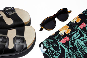 Sandalias de tiras negras de verano, gafas de sol, pantalon corto de flores 