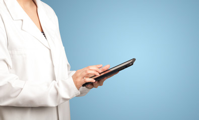 Female doctor holding tablet with blue background 