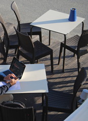 Trabalhando no exterior, pessoa sentada numa mesa no exterior a utilizar um computador portátil