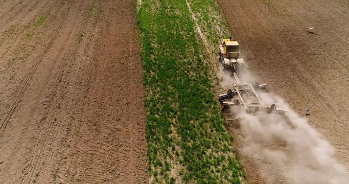 Aerial footage of a tractor on a field.