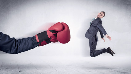 Huge Boxing Gloves punches innocent businessman concept
