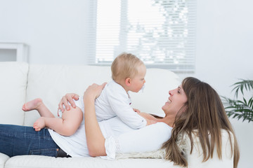 Mother lying on a sofa holding a baby on her chest