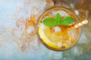 Traditional iced tea with lemon, mint and ice in tall glasses. A glass of refreshing summer drink...