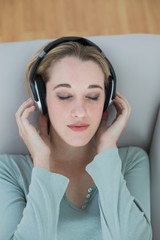 Enjoying natural woman listening with headphones to music with eyes closed