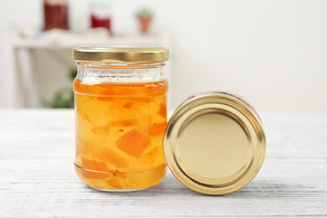 Two jars with tasty sweet jam on wooden table