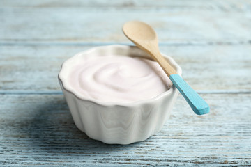 Fototapeta na wymiar Bowl with tasty yogurt on wooden background