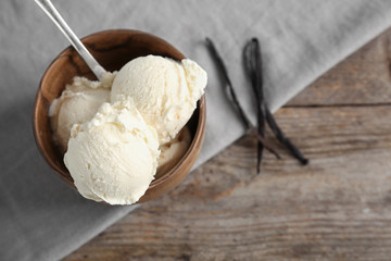 Wooden bowl with tasty vanilla ice cream on table - Powered by Adobe