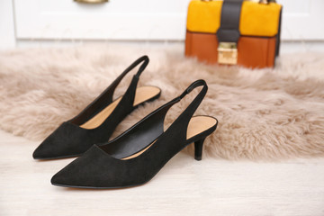 Pair of elegant female shoes on floor