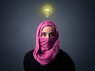 Young muslim woman wearing niqab with lit lightbulb above her head