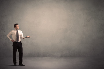 Caucasian businessman standing in front of a grunge, blank wall