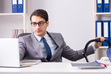 Businessman looking after newborn baby in office