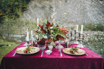 Elegant table set up for marsala or burgundy outdoor wedding