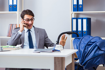 Businessman looking after newborn baby in office