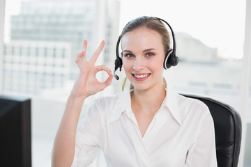 Happy call centre agent looking at camera giving ok sign