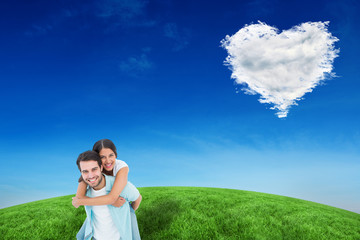 Happy casual man giving pretty girlfriend piggy back against cloud heart