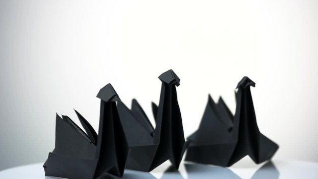 Three paper swans on white background. Composition of three origami birds. Amazing artistic work.