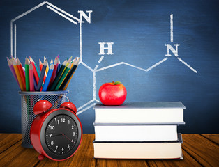 School supplies against blue chalkboard - Powered by Adobe