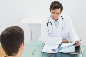 Doctor explaining xray reports to patient in office