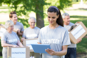 Smiling volunteer brunette using tablet pc 