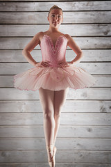 Pretty ballerina in pink standing en pointe against wooden planks © vectorfusionart