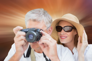 Vacationing couple taking photo against sunrise over mountains