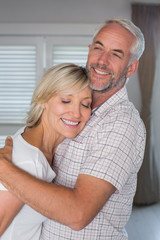 Mature couple embracing at home