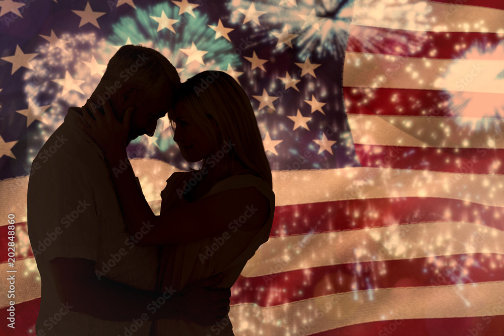 Poster affectionate couple standing and hugging against colourful fireworks exploding on black background