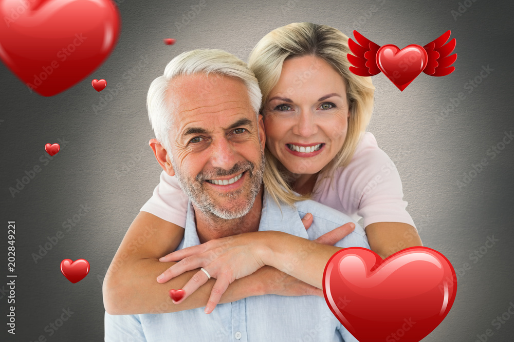 Poster smiling couple embracing and looking at camera against white background with vignette