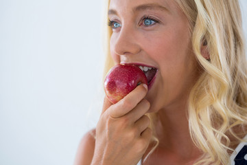 Close-up of beautiful woman eating red apple