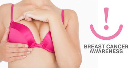 Closeup of woman performing self breast examination against breast cancer awareness message