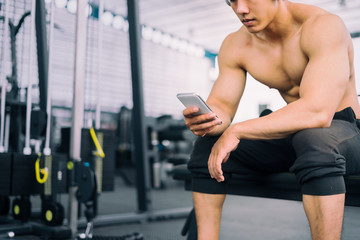 Obraz premium Fitness man relaxing seat listening to music after he exercises, fitness concept, sport concept