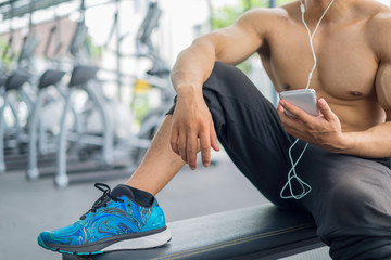 Naklejka premium Fitness man relaxing seat listening to music after he exercises, fitness concept, sport concept