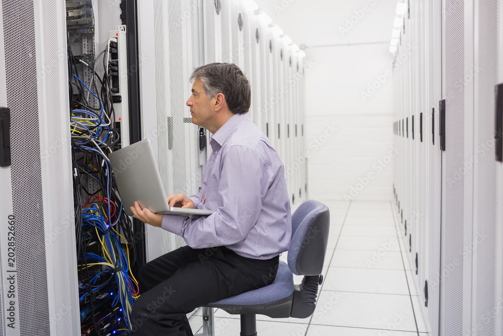 Poster technician controlling the server with a laptop